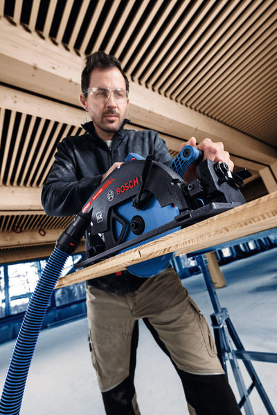 Eine Person mit Sicherheitsausrüstung verwendet eine Akku-Kreissäge zum Schneiden von Holz