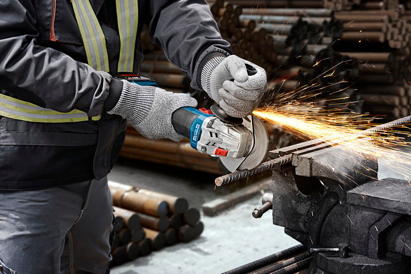 Eine Person mit Schutzausrüstung schneidet mit einem Winkelschleifer eine Metallstange, wobei Funken entstehen.