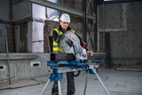 Eine Person mit Sicherheitsausrüstung bedient auf einer Baustelle eine Metalltrennsäge.