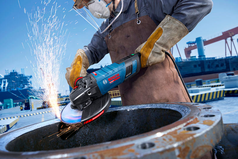 Ein Arbeiter mit Sicherheitsausrüstung verwendet einen Winkelschleifer und erzeugt Funken auf einer Metalloberfläche