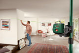 Eine Person markiert eine Wand mithilfe eines Laser-Nivelliergeräts, das eine grüne Linie projiziert.
