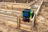 Auf einer schlammigen Baustelle ist ein Laser-Nivelliergerät auf einer Holzschalung aufgebaut.