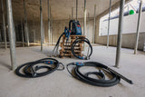 Baustelle mit zwei Betonrüttlern und einem tragbaren Netzteil auf einer Palette.